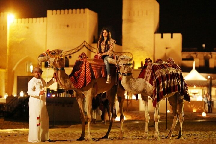 Immerse in a magical Arabian night while riding camels under the starlit sky surrounded by stunning fortress architecture and the whispers of ancient traditions creating lasting memories in Dubai's desert.